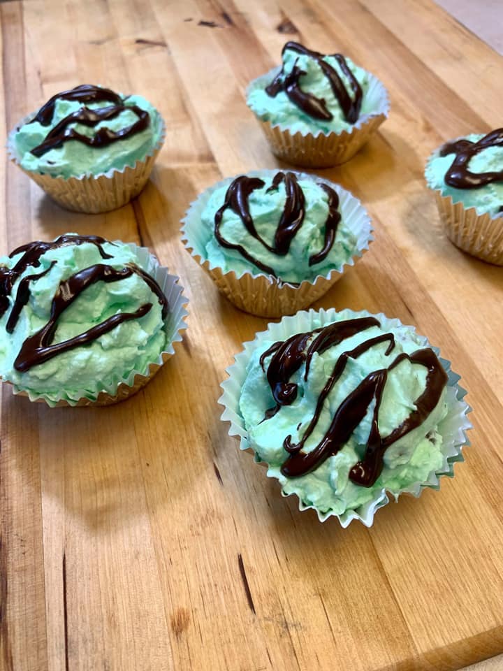 6 mint chocolate chip cupcakes on a wooden table