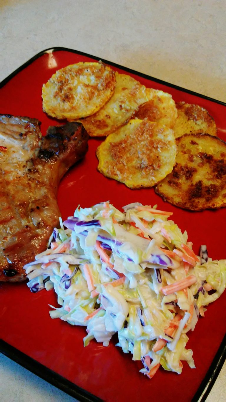 red plate filled with pork chops, keto cole slaw and fried squash