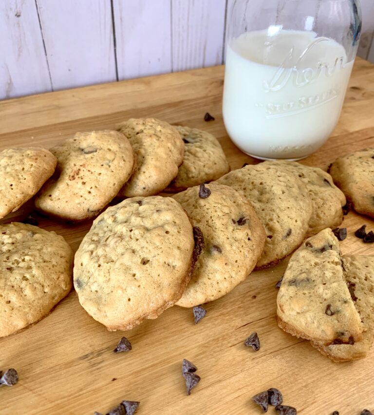 stacked up chocolate chip cookies and glass of milk