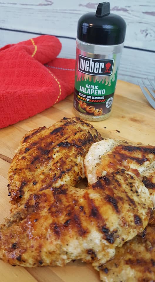 grilled chicken breast and Weber garlic jalapeno seasoning on a cutting board
