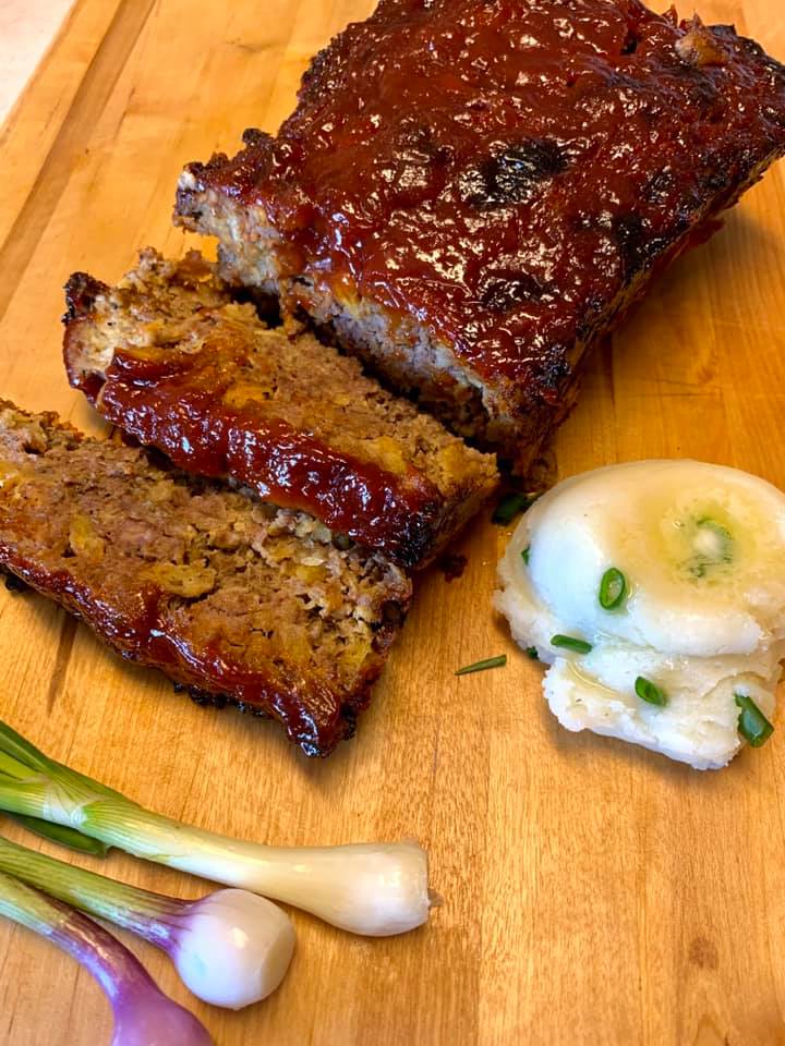 meatloaf and smashed potatoes on a cutting board