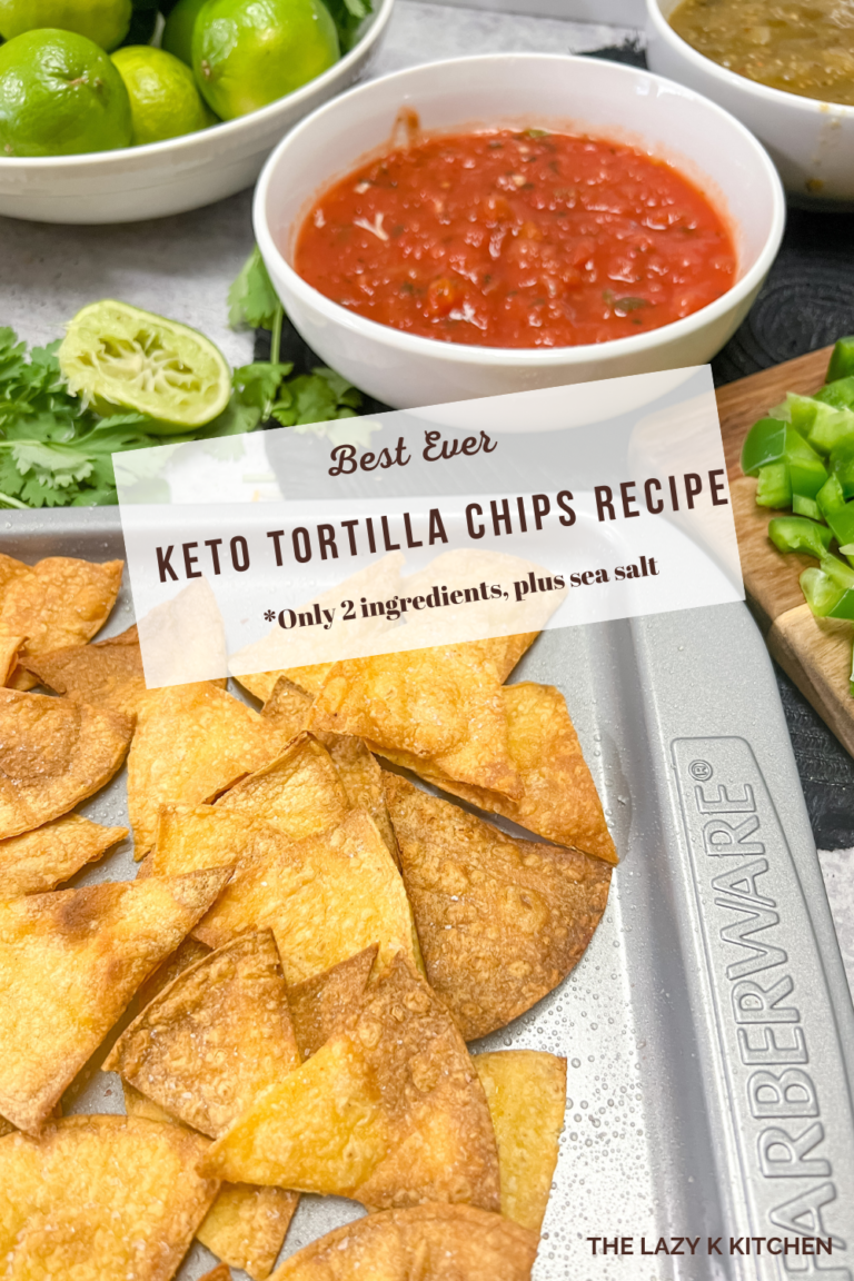 tortilla chips on a grey baking sheet and a white bowl filled with red salsa