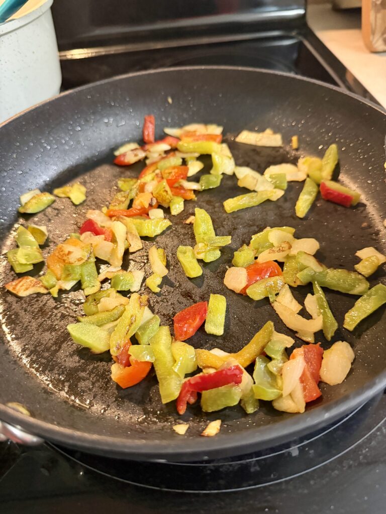 skillet of cooked bell peppers and onions