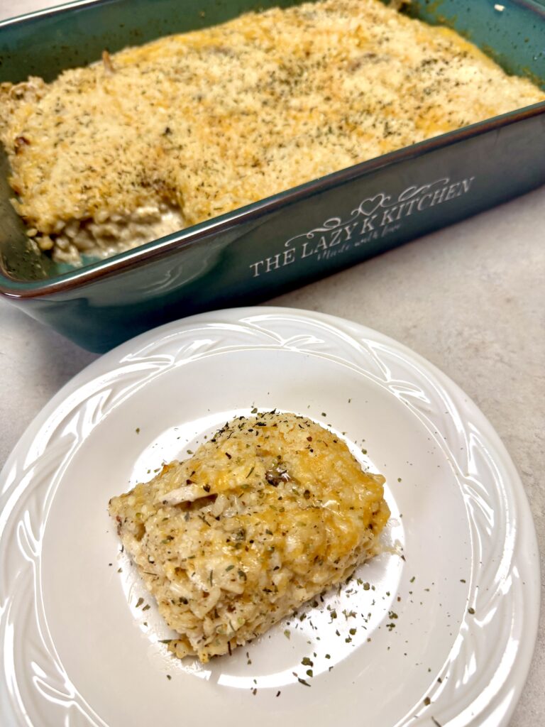 green baking dish and a white plate with chicken alfredo rice casserole on them