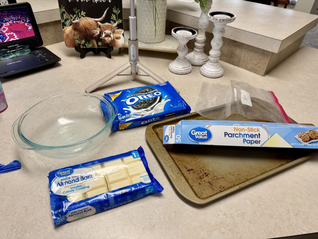 Picture of ingredients for a recipe, Oreo cookies, almond bark, a baking sheet and bowl.