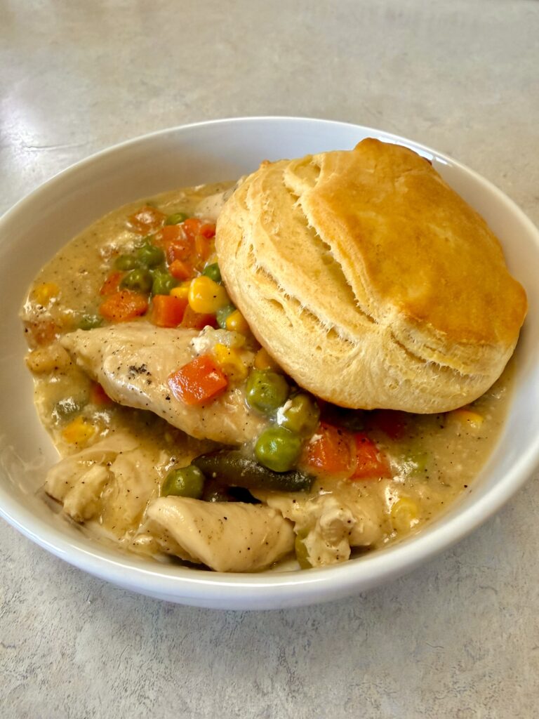 Picture of chicken pot pie in a white bowl.