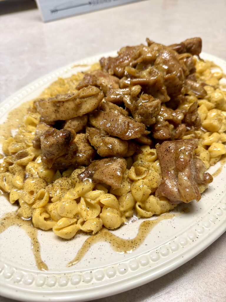 Picture of honey pepper chicken mac and cheese on a white platter.