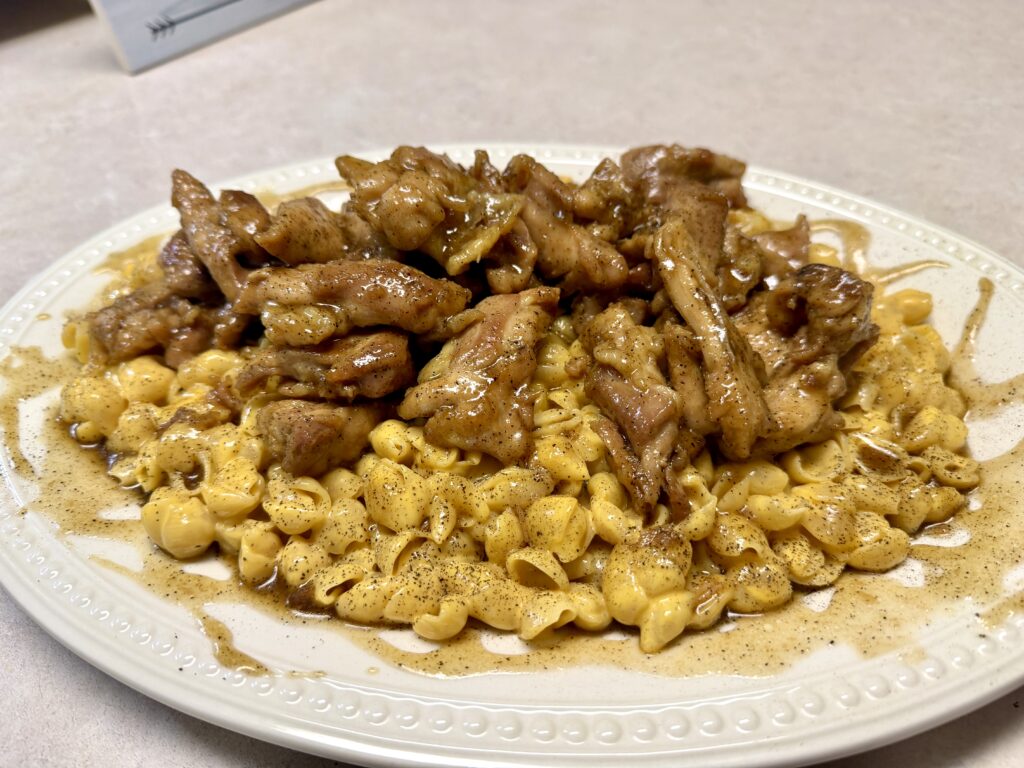 Picture of honey pepper chicken mac and cheese on a white platter.