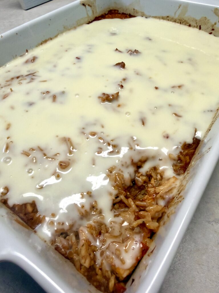 Picture of chicken fajita queso bake in a white baking dish.
