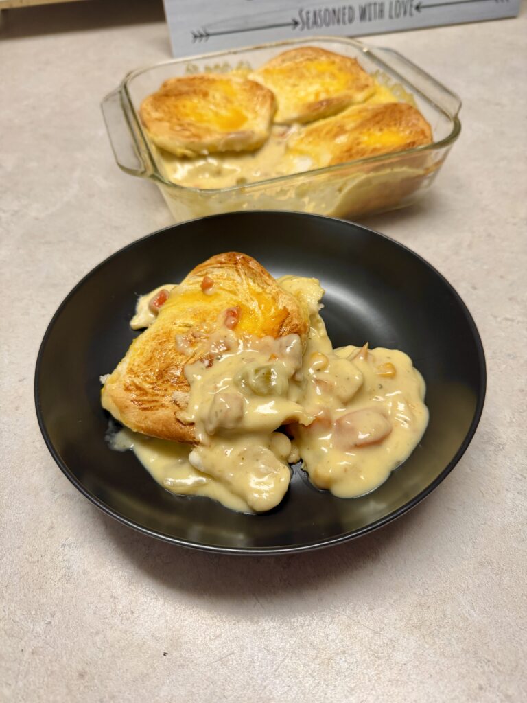 Picture of 3 ingredient chicken pot pie in a baking dish and on a black plate.