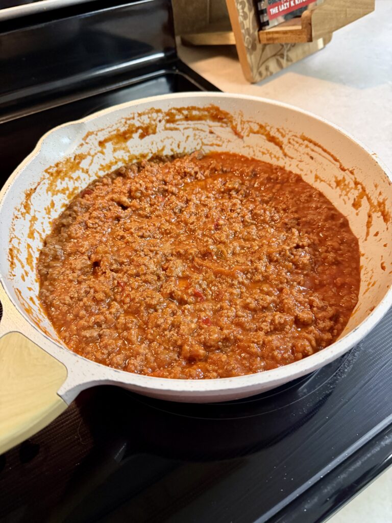 Picture of a white skillet with sloppy joe ground beef.