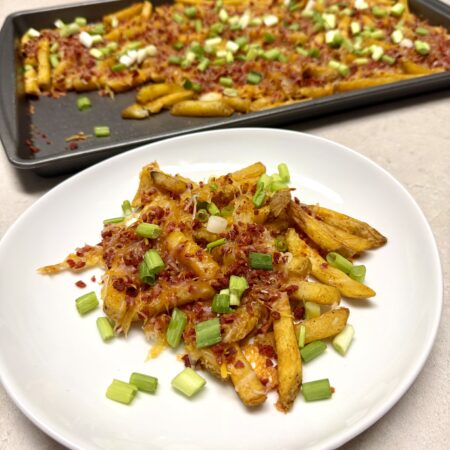 bacon cheese fries on a white plate