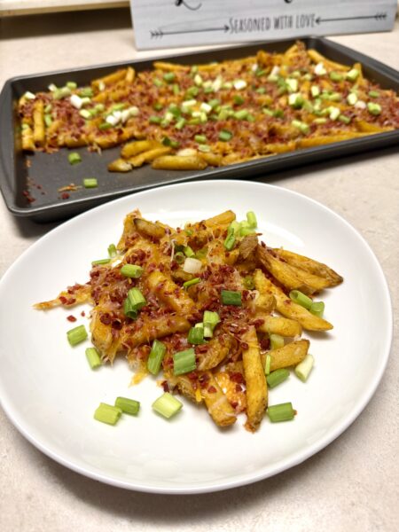 bacon cheese fries on a white plate