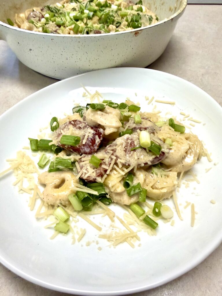 smoked sausage alfredo on a white plate