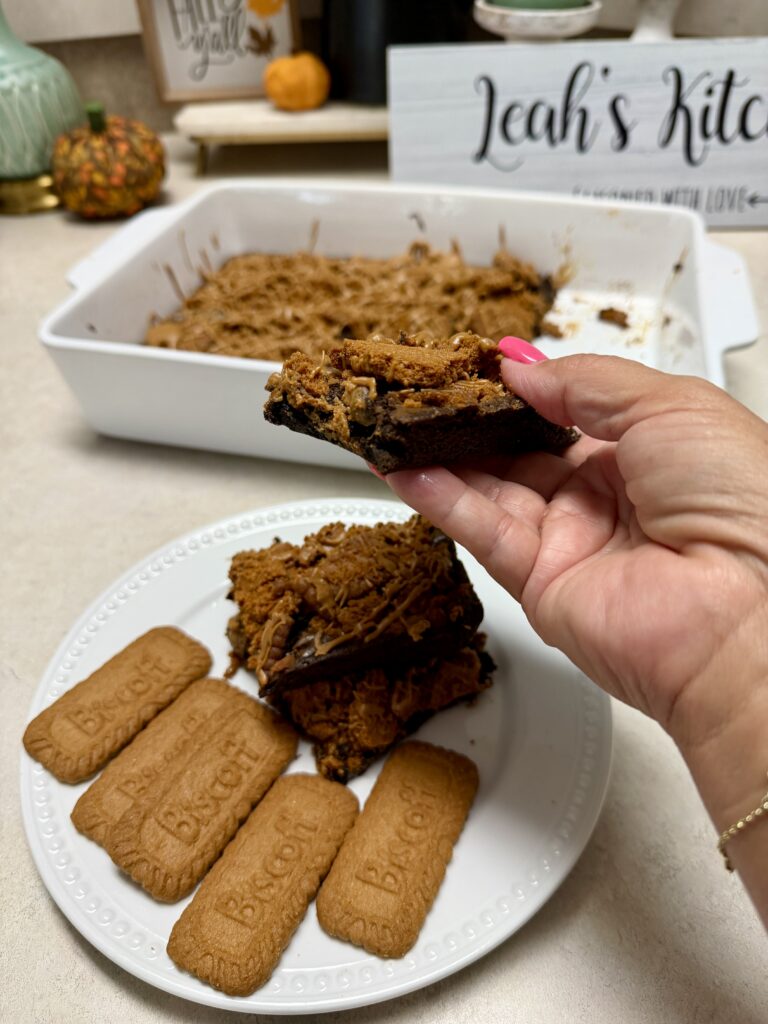 brownies on a white plate and a hand holding one brownie